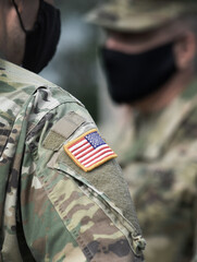 American flag on soldier arm and US soldiers wearing protective face masks. Quarantine in army....