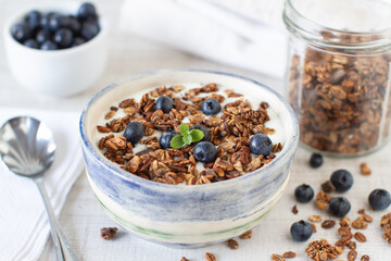 Homemade granola with blueberries and yoghurt on a table Healthy food, clean eating, dieting concept
