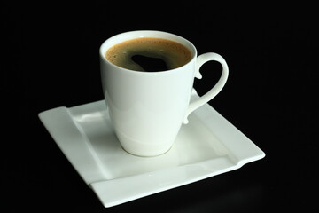 Black coffee in a white cup on a black background