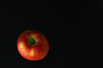 A Polish red apple on a black background
