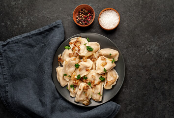Dumplings stuffed with stewed cabbage on a stone background