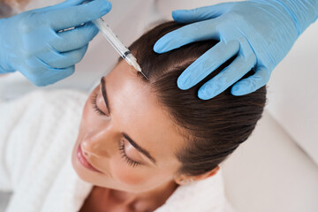 Lady during procedure in cosmetology clinic
