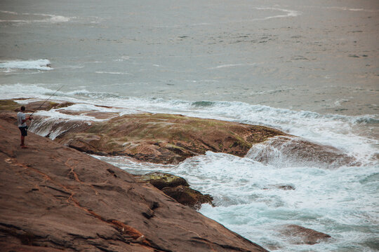 Person fishing on a rocky coast