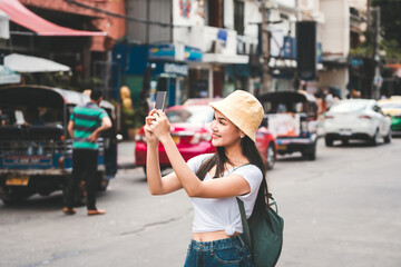 Young adult asian traveller women using mobile application for online social networ