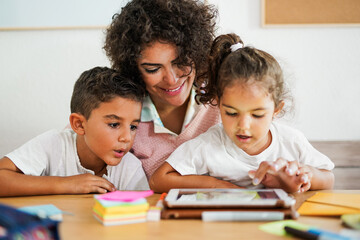 Mother teaching children at home in time of coronavirus - Learning with digital tablet