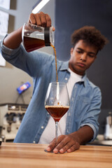 Man pouring coffee from a jug into a glass