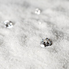 Beautiful, round white diamonds of many sizes are expensive jewelry placed on white sand.
