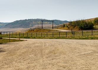 large dirt area by a fence