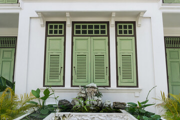 vintage green wooden shutter window on white building, Thailand