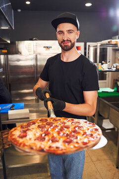 Pizzaiolo Holding Pizza On Peel