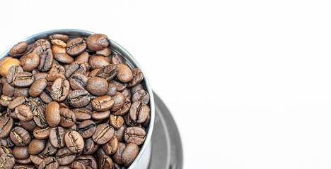 A lot of coffee beans in a metal coffee grinder on a white background