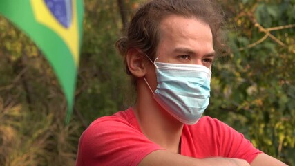 COVID-19 pandemic in Brazil. A young, attractive sad Brazilian Latin American man in protective medical mask. Coronavirus. Quarantine.  - Powered by Adobe