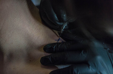 Closeup shot of a tattoo artist tattooing a client's shoulder