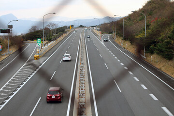 Blurred fence overlooking Japanese highway, taken in Beppu