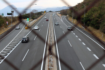 Blurred fence overlooking Japanese highway, taken in Beppu