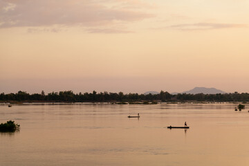 Obraz na płótnie Canvas Muong Khong Laos 1/12/2012 Mekong river at dawn with golden sun and fishing boat