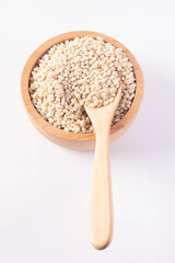 Barley rice in a wooden cup on a white background