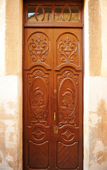 Two-leaf wooden door with Roman soldiers in profile in Cáceres, Extremadura, Spain
