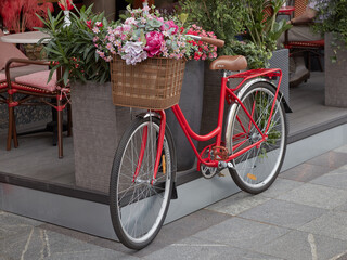 Fototapeta na wymiar Vintage red bicycle with a basket of flowers