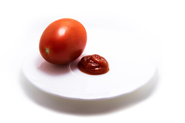 Ketchup and tomato on one plate on white isolated background