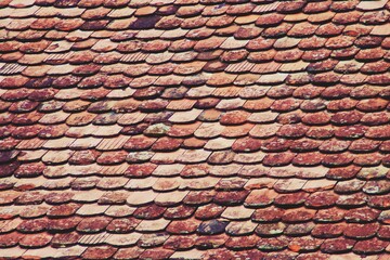 Tejado de tejas tradicional en un viejo edificio medieval de Sighisoara, Rumanía. Fondo uniforme y rojizo de tejas.