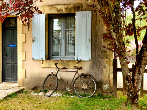 French house with old rusty bicycle outside