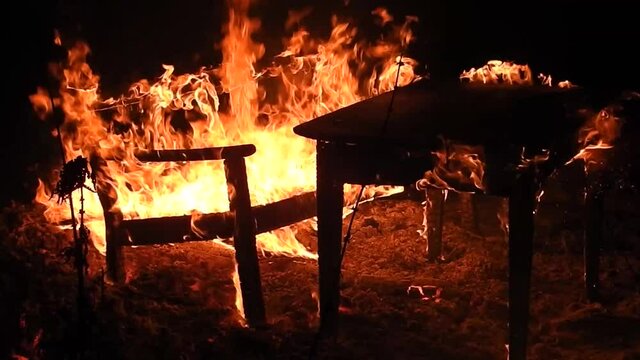 Table and bench burning in a huge fire. Hot seat, isn't it?