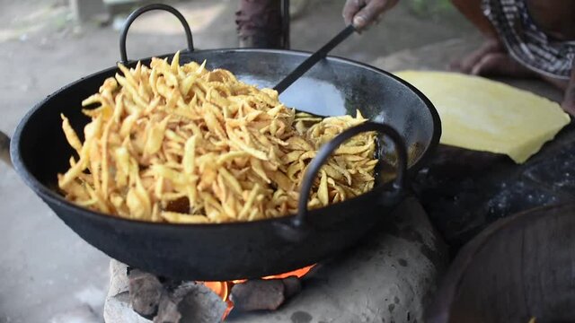 A man using mesh skimmer to fry Indian street snacks at a fair, SLOW MOTION