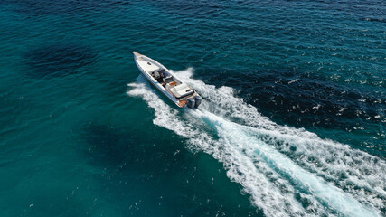 Aerial drone photo of luxury inflatable speed boat cruising in deep blue Aegean sea, Mykonos island, Cyclades, Greece