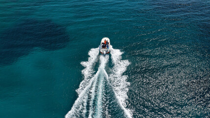 Aerial drone photo of luxury inflatable speed boat cruising in deep blue Aegean sea, Mykonos island, Cyclades, Greece