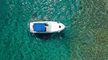 Aerial drone photo of luxury power boat cruising in deep blue sea near Mediterranean Aegean island