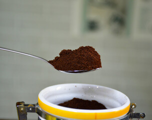 ground coffee in a teaspoon close-up. bottom container for storing ground coffee