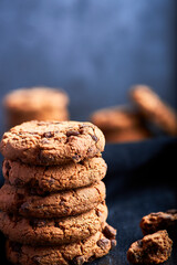 cookies with chocolate shavings on top of a plate on a black background.