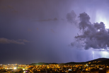 The lightning in the night sky over the city.