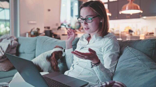 Young Business Woman Working From Home On Computerю SLOW MOTION. Conference call on laptop, Suit and pyjamas. Female learning online. Mess in a room. Entrepreneur Work life balance. 