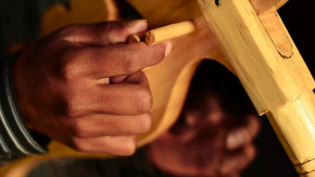 Hands tuning traditional Harp.