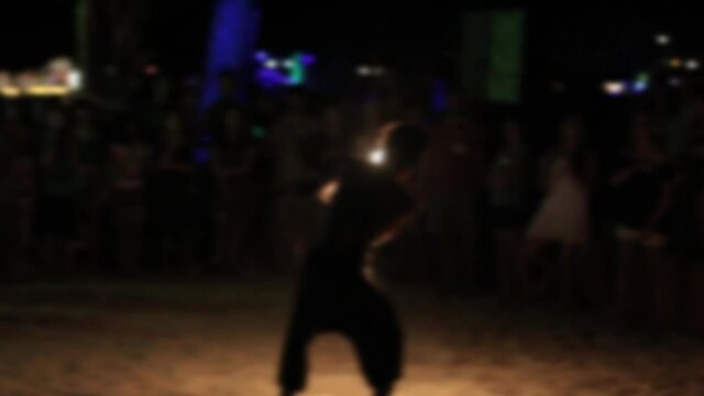 Fire dancer spinning flames for a crowd, BLURRED SLOW MOTION