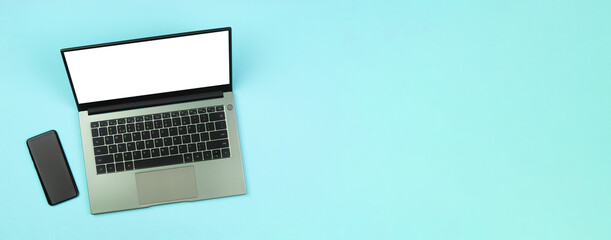 A banner with a smartphone and a white mockup on a laptop screen on a blue background top view