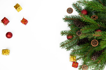 Branches of a Christmas tree and red and yellow gift boxes and balls on a white background. Christmas background with copyspace.
