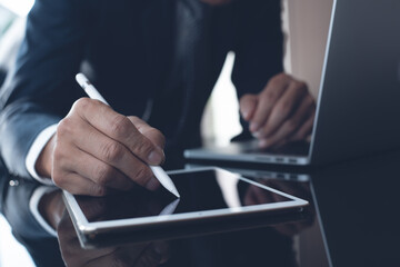 Businessman signing contract or proofing business document with stylus pen on digital tablet in...