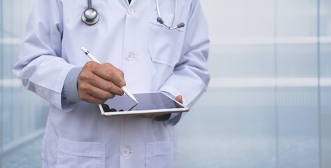 Male doctor writing medical data or prescription by using stylus pen working on digital tablet in hospital - obrazy, fototapety, plakaty