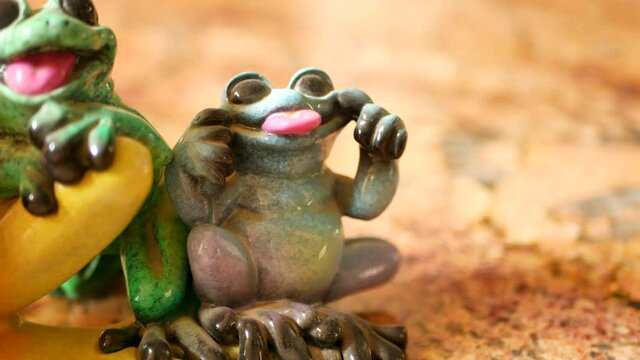 Ceramic blue smiling frog figurine ORBITING.