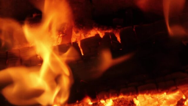Burning Firewood Coal Close up in the Fireplace. Fire Fireplace Ember Wood Home Embers Closeup. Glowing Embers in Hot Red Collor. static tripod shoot.