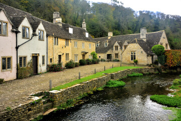 Fototapeta na wymiar Riverside Stone Cottages at Castle Coombe in the Cotswolds