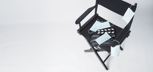 Director chair and face mask and black Clapper board or movie slate. it use in video production and...