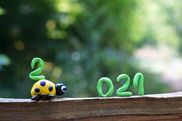 Figure 2021. Next to it is a figurine of a ladybug made of plasticine. The number 2 is located on the figure.