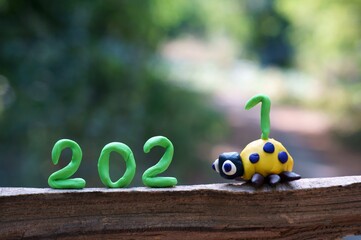 Figure 2021. Next to it is a figurine of a ladybug made of plasticine. The number 1 is located on the figure.