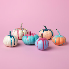 Autumn layout made of colorful pumpkins with dripping paint on pink background. Minimal Fall or Halloween concept.