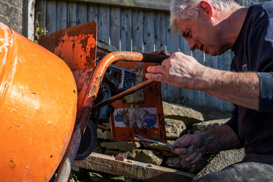Senior Male fixing cerment mixer belt by setting tension of belt to prevent from slipping