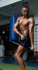 Naklejka na ściany i meble bodybuilder posing. Beautiful sporty guy male power. Fitness muscled man